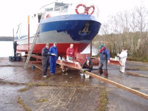 Volunteers painting the Inishcruiser, Share Discovery Village, Co Fermanagh, N. Ireland